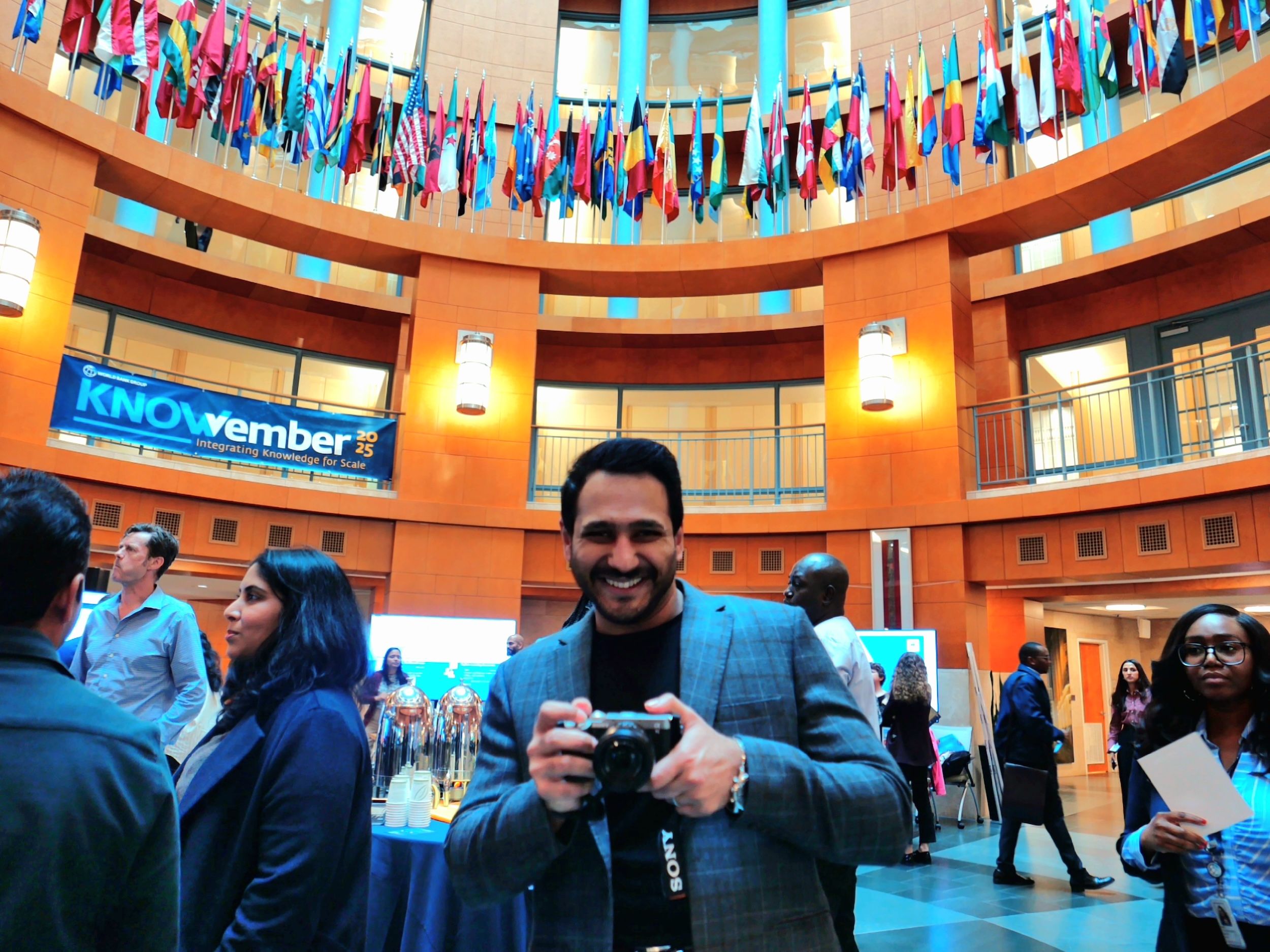 A photo of Ali Lodhi holding a camera at KNOWvember, a World Bank Group event where he was the evaluation lead